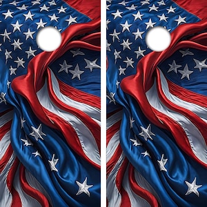 May include: A pair of cornhole boards featuring a high-resolution print of a draped American flag. The design displays flowing red, white, and blue fabric textures with white stars scattered across the surface. Each board has a circular hole.