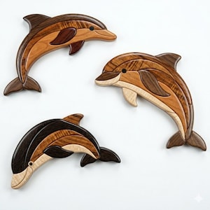 May include: Three wooden dolphin sculptures in varying shades of brown and tan. Each dolphin has a curved body, fins, and a small black eye. The wood grain is visible, adding texture to the marine animal art.