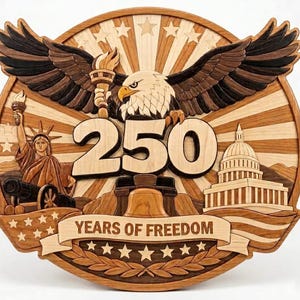 May include: A wooden plaque featuring a bald eagle with outstretched wings, a torch, and the Statue of Liberty. The number "250" is prominently displayed, along with the text "YEARS OF FREEDOM" on a banner. The design incorporates stars and a depiction of the Capitol building.