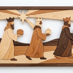 May include: A rectangular wooden wall art piece featuring a marquetry scene of three figures wearing crowns and robes, each carrying a small box. Above them, a large star radiates light beams. The scene is crafted from various wood tones.
