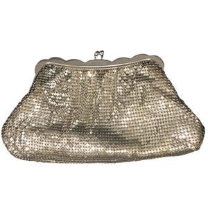 Könnte beinhalten: Eine weiße Keramik-Tasse mit schwarzem Henkel und dem Text "But First, Coffee" in fetter, schwarzer Schrift. Die Tasse steht vor einem verschwommenen Hintergrund, der eine gemütliche Umgebung suggeriert. Die Tasse ist etwa 10 cm hoch.