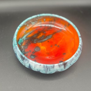Cuenco artístico de cerámica de estudio firmado por Ana Clara, color naranja, rojo y turquesa, con esmaltado por goteo.