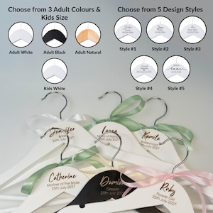 Puede incluir: Una colección de perchas de madera personalizadas en blanco y negro, con ganchos cromados y cintas de satén en verde salvia y rosa suave. Las perchas están personalizadas con nombres, roles y fechas en letra cursiva negra, con una tabla de referencia.