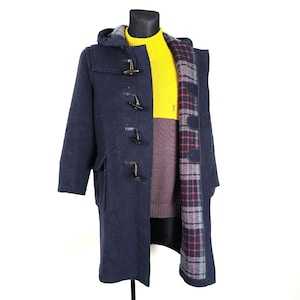 May include: A navy blue duffle coat with a plaid lining and a hood. The coat has a series of toggle closures down the front.