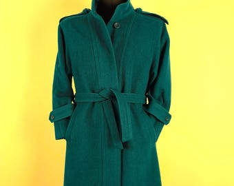 May include: A teal blue long-sleeved coat with a belt and a button closure. The coat has a collar and pockets.