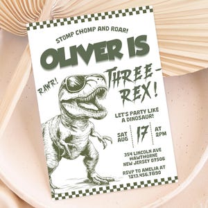 May include: A green and white dinosaur birthday party invitation with the text "Oliver is Three-Rex!" and a cartoon dinosaur wearing sunglasses. The invitation includes the date, time, and location of the party.