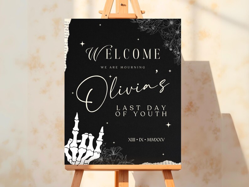 May include: Black welcome sign with white text that reads "Welcome, We are mourning Olivia's Last Day of Youth, XIII - IX - MMXXV". The sign has a white skeleton hand giving the middle finger and floral designs.
