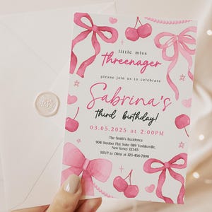 May include: Pink birthday invitation with watercolor illustrations of bows, cherries, and hearts. The text reads "little miss threenager" and "Sabrina's third birthday!" with the date and time of the party.