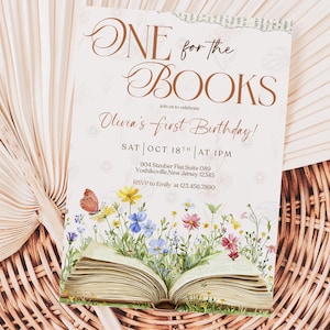 Puede incluir: Una invitación de cumpleaños con el texto "ONE for the BOOKS" y "Olivia's first Birthday!". La invitación presenta un libro abierto con flores coloridas y una mariposa. La fecha es el 18 de octubre a la 1 PM.