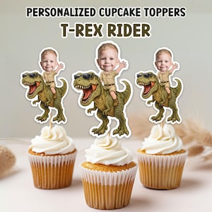 May include: Three cupcakes with personalized T-Rex Rider toppers. Each topper shows a cartoon child riding a green dinosaur. The cupcakes have white frosting. The text "PERSONALIZED CUPCAKE TOPPERS" and "T-REX RIDER" are at the top of the image.