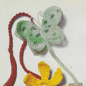 May include: Crocheted bookmarks featuring a butterfly, flower, and heart design. The butterfly is green and white, the flower is yellow with green leaves, and the heart is red.