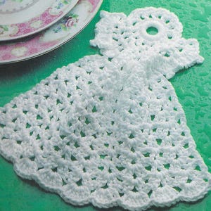 May include: White crocheted dishcloth with a scalloped edge and a circular hole in the center.