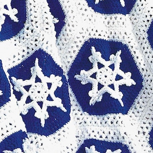 Könnte beinhalten: Eine gehäkelte Decke mit einem Schneeflockenmuster in Weiß und Blau. Die Decke ist aus weichem, strukturiertem Garn gefertigt.