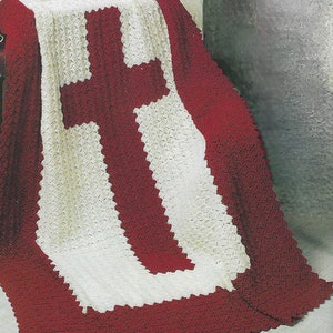 May include: A crocheted throw blanket with a large red cross design in the centre. The blanket is made with white and red yarn.