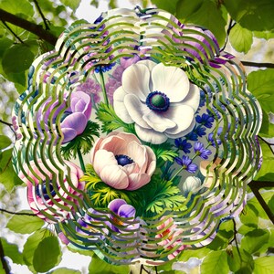 May include: A floral design featuring a variety of flowers, including white, pink, and purple anemones, with green foliage. The flowers are arranged in a circular pattern, surrounded by a wavy green and purple border, set against a backdrop of green leaves.