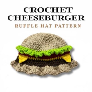 Op de afbeelding: Een gehaakte hoed ontworpen om op een cheeseburger te lijken. De hoed heeft een bruine kroon, een groene, op sla lijkende ruche en lagen bruin, rood en geel, die de ingrediënten van de burger nabootsen. De tekst "CROCHET CHEESEBURGER RUFFLE HAT PATTERN" staat erboven.