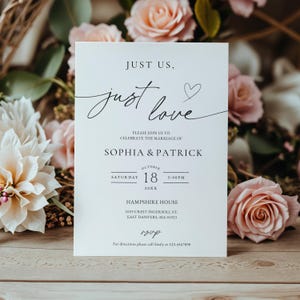 May include: A white wedding invitation card featuring black text that reads Just Us, just love, with a small heart icon. The card includes the names Sophia & Patrick, the date October 18, 20XX, at 3:00 PM, and the location Hampshire House in Danvers, MA.