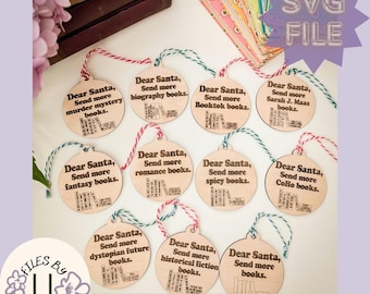 May include: Ten round wooden ornaments with a laser-cut design of stacked books and text that reads "Dear Santa, Send more [book genre] books."