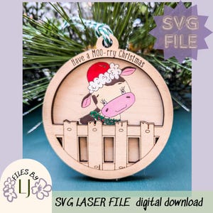 May include: A wooden Christmas ornament featuring a cartoon cow wearing a Santa hat and peeking over a fence. The ornament is round and has the text "Have a MOO-rry Christmas" printed on it.