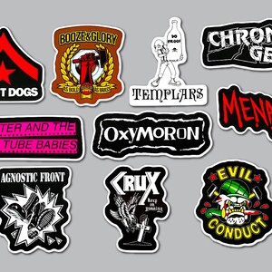 May include: A collection of nine punk rock band stickers featuring various logos and graphics. Included are Street Dogs, Booze & Glory, Templars, Chron Gen, Menace, Peter and the Test Tube Babies, Oxymoron, Agnostic Front, Crux, and Evil Conduct designs.