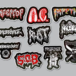 May include: A collection of ten die-cut vinyl stickers featuring various band logos and graphic designs in black, white, and red. The stickers display text including GoreBeyondNecropsy, Haemorrhage, Nausea, Brujeria, and S.O.B. with intricate, jagged lettering.