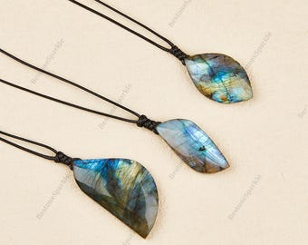 Collar con colgante de labradorita en forma de hoja: piedra irregular con destellos y cordón de cuero.