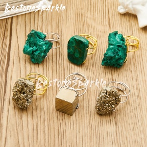 Op de afbeelding: Zes verstelbare ringen met verschillende edelsteen bezettingen. De ringen hebben een ontwerp van gouden of zilveren draad. De stenen omvatten groene malachiet en gouden pyriet.