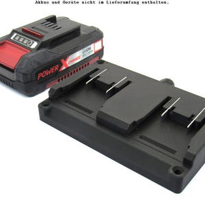 Könnte beinhalten: Schwarzer und roter Power X Li-Ion Akku und Ladegerät. Der Akku ist schwarz mit rotem Akzent und das Ladegerät ist schwarz mit zwei Steckplätzen für Akkus. Der Text "POWER X" ist auf dem Akku sichtbar.