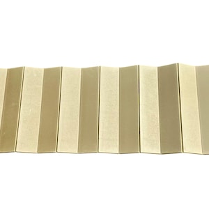 May include: A beige and white folding camping mat with two straps on the right side.
