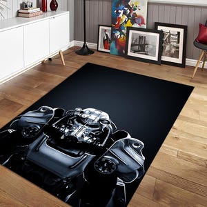 Puede incluir: Una alfombra rectangular con una ilustración detallada de un traje blindado futurista y metálico. El diseño es predominantemente plateado y gris, sobre un fondo azul oscuro. El diseño de la alfombra es un primer plano de la parte superior del cuerpo de la armadura.