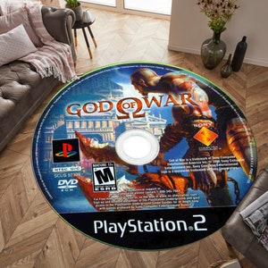 May include: A blue and red PlayStation 2 game disc for God of War II. The disc features a close-up of Kratos, the main character, holding a sword and standing in front of a city. The text "God of War" is written in a large font on the disc.