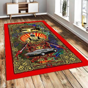 May include: A rectangular rug with a red border and an intricate central design. The design includes a car, a figure within a circle, and ornate patterns in gold, red, and blue. The rug is placed on a wooden floor.