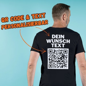 Op de afbeelding: Zwart T-shirt met een witte QR-code en de tekst "DEIN WUNSCH TEXT" gedrukt op de achterkant.
