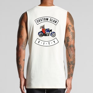 May include: White sleeveless tank top with a graphic of a cartoon character riding a motorcycle. The graphic includes the text "CUSTOM CLUB CITY".