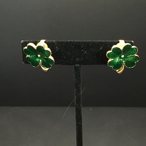 May include: A pair of gold-tone clip-on earrings featuring green enamel four-leaf clover designs.
