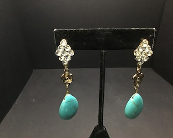 May include: A pair of dangle earrings with a turquoise stone and a cluster of clear rhinestones.