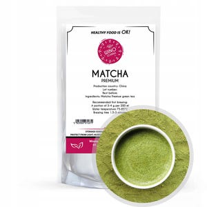 Puede incluir: Una bolsa de polvo de matcha verde con una taza blanca de té matcha. La bolsa tiene una etiqueta que dice "Matcha Premium" y "Healthy Food is OK!" La etiqueta también incluye información sobre el producto, como el país de producción, el número de lote, la fecha de caducidad, los ingredientes y las instrucciones de preparación recomendadas.