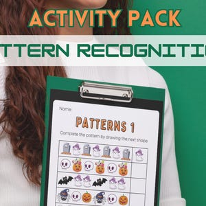 Könnte beinhalten: Eine grüne und schwarze Klemmbrett mit einem Halloween-Mustererkennungs-Arbeitsblatt. Das Blatt hat den Titel "Patterns 1" und Anweisungen, um das Muster zu vervollständigen, indem die nächste Form gezeichnet wird. Das Blatt enthält Bilder von Geistern, Kürbissen, Fledermäusen und Spinnen.