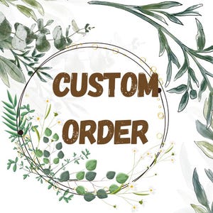 Puede incluir: Un diseño circular con las palabras "CUSTOM ORDER" en marrón, rodeado por una corona de hojas verdes y flores blancas. El fondo presenta follaje verde adicional y un fondo blanco.