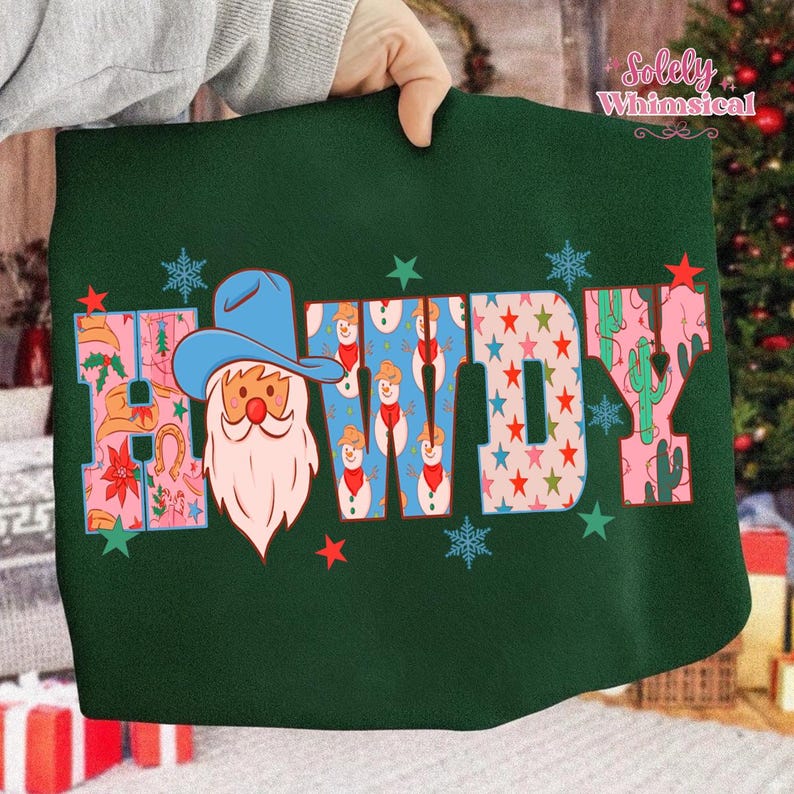 K&ouml;nnte beinhalten: Dunkelgr&uuml;nes Sweatshirt mit dem Wort "HOWDY" in einem farbenfrohen Design. Das "H" zeigt einen Cowboy-Weihnachtsmann, die "O"s haben Schneemannmuster und die "W" und "Y" haben Stern- und Kaktusmuster. Schneeflocken- und Sternakzente.