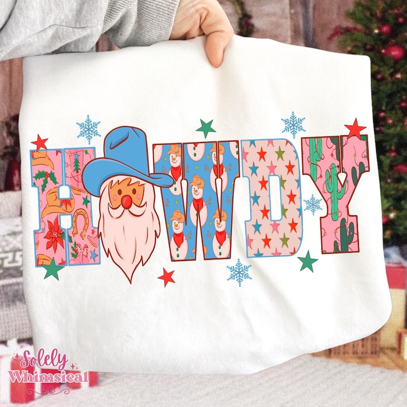 K&ouml;nnte beinhalten: Wei&szlig;es Sweatshirt mit dem Wort "HOWDY" in bunten Buchstaben. Das "H" zeigt einen Weihnachtsmann mit Cowboyhut. Das "W" hat ein Schneemannmuster und das "Y" ein Kaktusdesign. Rote Sterne und blaue Schneeflocken sind um das Wort herum verstreut.