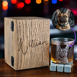 Puede incluir: Caja de madera personalizada con el nombre "William" grabado en ella. La caja est&aacute; al lado de un vaso de whisky con un Bulldog Franc&eacute;s grabado en el lateral. El vaso est&aacute; lleno de un l&iacute;quido marr&oacute;n y hay tres posavasos de piedra gris delante.