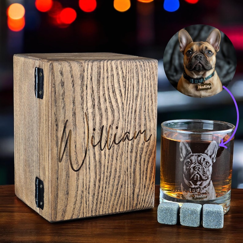 Puede incluir: Caja de madera personalizada con el nombre "William" grabado en ella. La caja est&aacute; al lado de un vaso de whisky con un Bulldog Franc&eacute;s grabado en el lateral. El vaso est&aacute; lleno de un l&iacute;quido marr&oacute;n y hay tres posavasos de piedra gris delante.