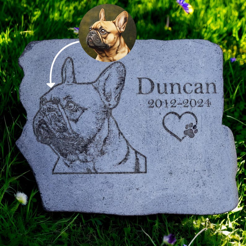 May include: A gray stone pet memorial with a detailed engraved image of a French Bulldog. The name "Duncan" and dates "2012-2024" are inscribed, along with a heart and paw print. A circular portrait of the dog is in the upper left.