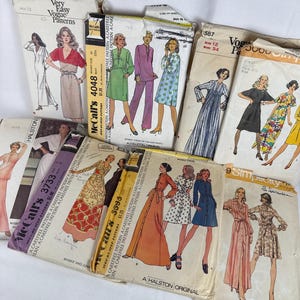 May include: A collection of vintage sewing patterns featuring illustrations of dresses and other garments. The patterns are from various brands, including Vogue, McCall's, and Simplicity. The patterns are in various sizes and styles, with some featuring the Halston label.