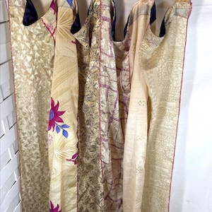 May include: A curtain panel made of vertical strips of fabric in shades of cream, gold, and beige, featuring floral patterns and geometric prints. A measuring tape is visible at the top, showing a width spanning from 3 to 20 inches.