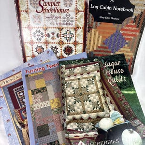 May include: A collection of quilting books, including "Sampler Schoolhouse" and "Log Cabin Notebook." The books feature colorful quilt designs and patterns. The covers display various quilt block arrangements and the titles of the books.