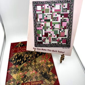 May include: Two instructional quilting books. The upright book is titled Turning Twenty... Again by Tricia Cribbs, featuring a pink, green, and white patchwork quilt. The flat book is titled 9-Patch by Judy Sisneros, showing a dark patterned quilt.