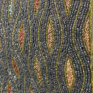 May include: A textile surface featuring an intricate pattern of vertical, wavy lines created with small, dark grey, and lime green beads. The spaces between these beaded lines are filled with rows of metallic copper and reddish-brown seed beads.