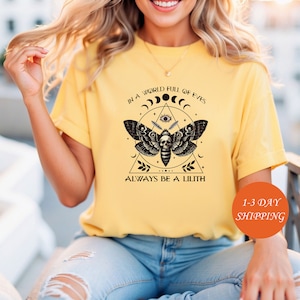 May include: A yellow t-shirt with a black and white moth graphic and the text "In a world full of eyes, always be a Lilith".